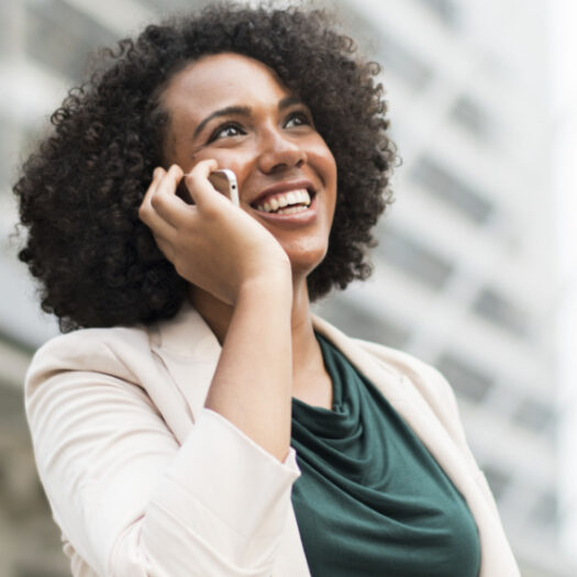 smiling woman conversing on cell phone