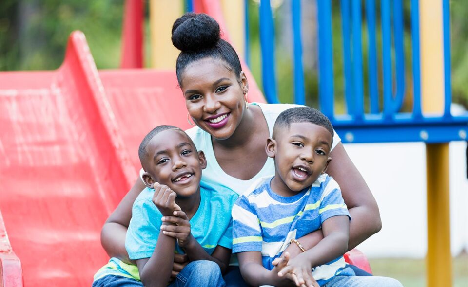 Mother with two sons on a playground slide