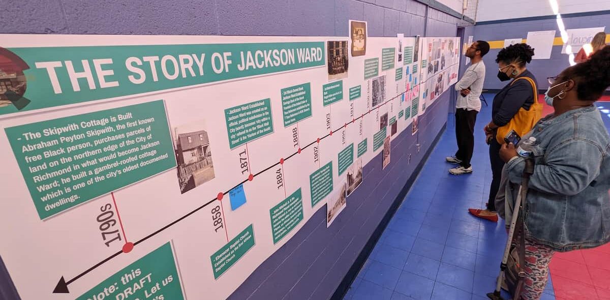 People looking at a timeline posted on the wall