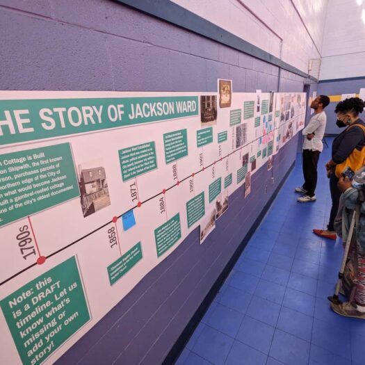 People looking at a timeline posted on the wall