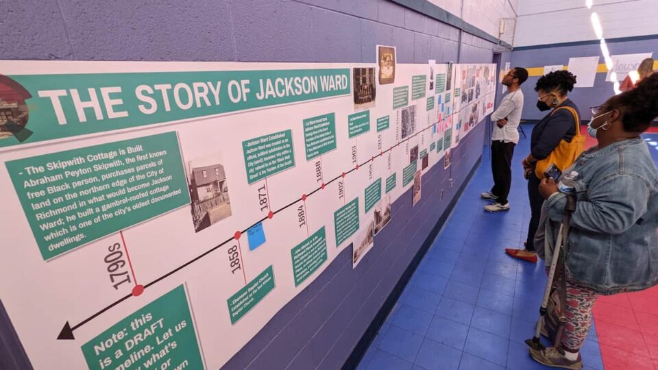 People looking at a timeline posted on the wall
