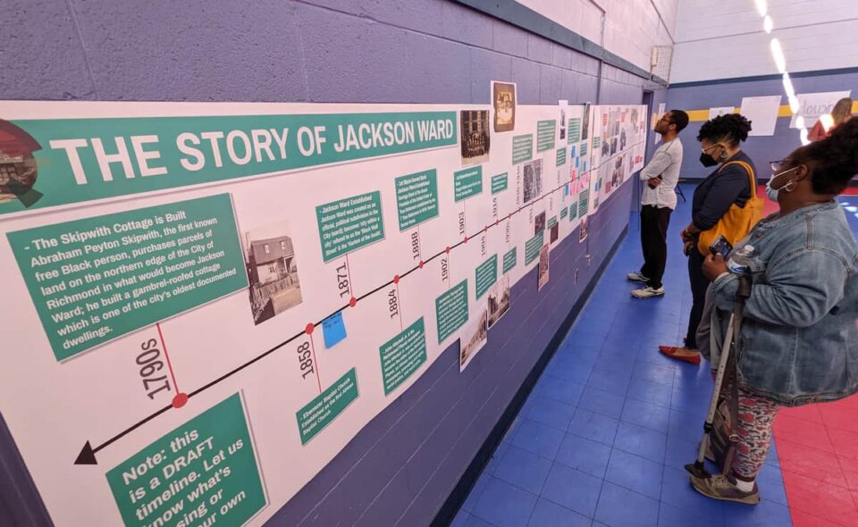 People looking at a timeline posted on the wall