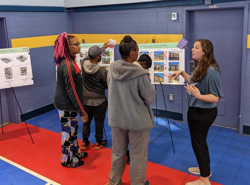 A family talking with a presenter in front of a display