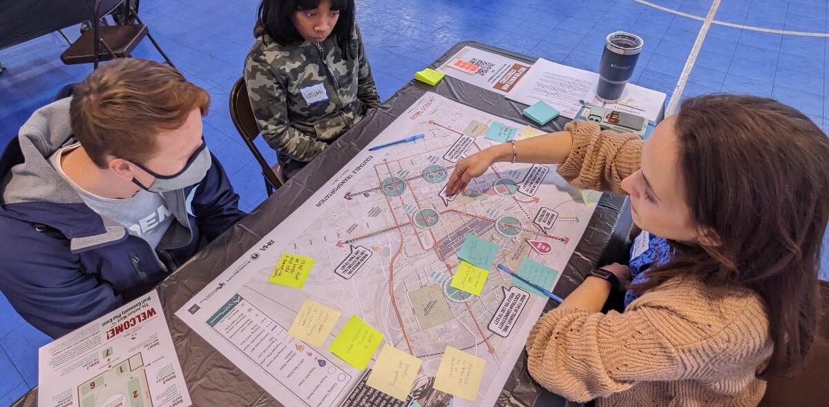 Three people sitting at a table and discussing a map