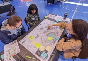Three people sitting at a table and discussing a map