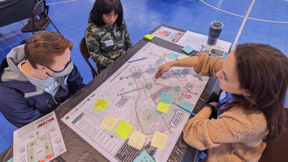 Three people sitting at a table and discussing a map