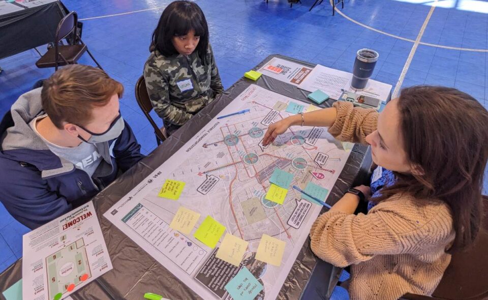 Three people sitting at a table and discussing a map