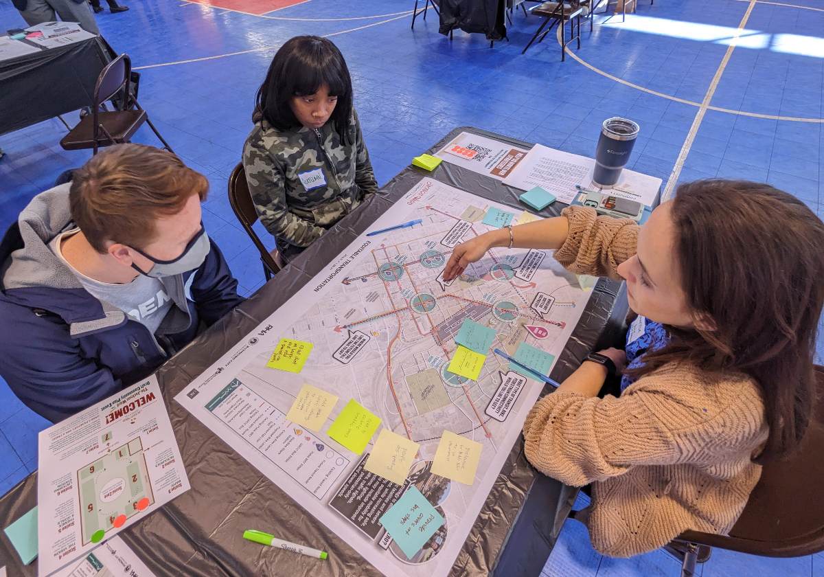 Three people sitting at a table and discussing a map