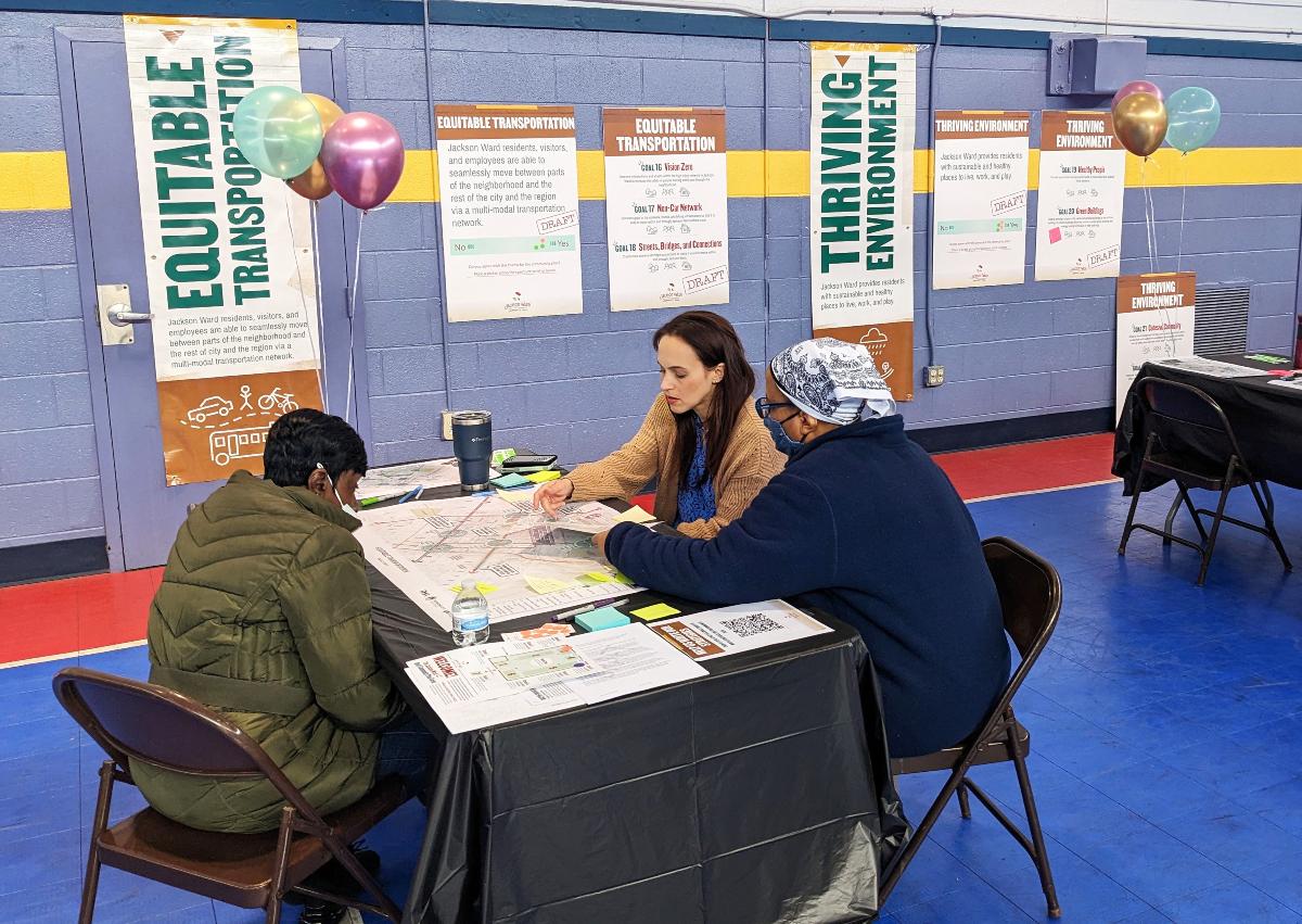 Two residents in discussion with an RRHA representative