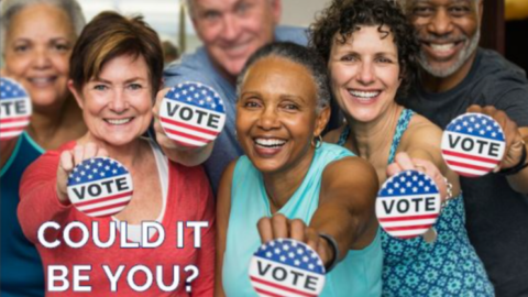 Group of people holding VOTE stickers