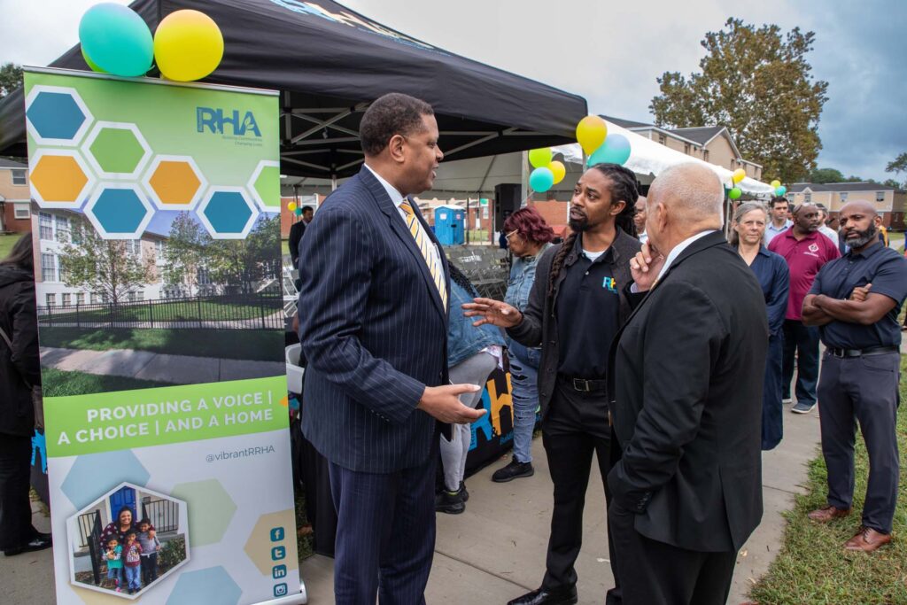 People talking at an outdoor event in a residential area
