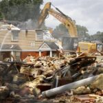 A construction vehicle demolishing an old home.