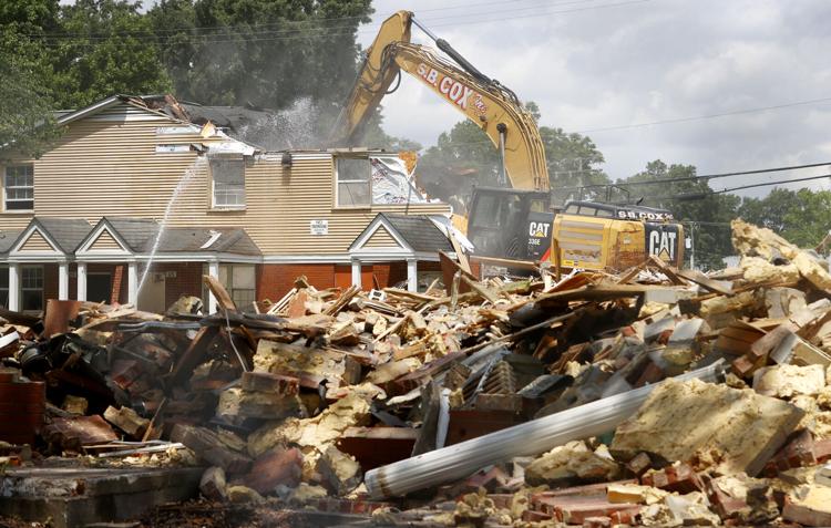 A construction vehicle demolishing an old home.